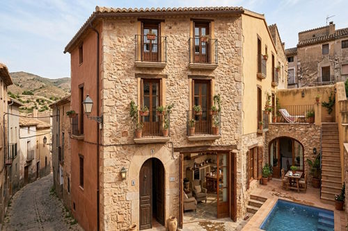 Guesthouse with natural stone facade, courtyard and pool in a rural village setting in the Valencia region, Spain