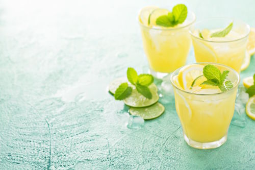 fresh alcohol-free summer drink with citrus, mint and ice served in modern glass